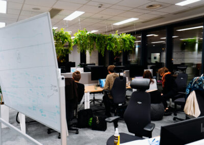 Sala w biurowcu, noc, uczestnicy hackathonu pracują przy biurkach